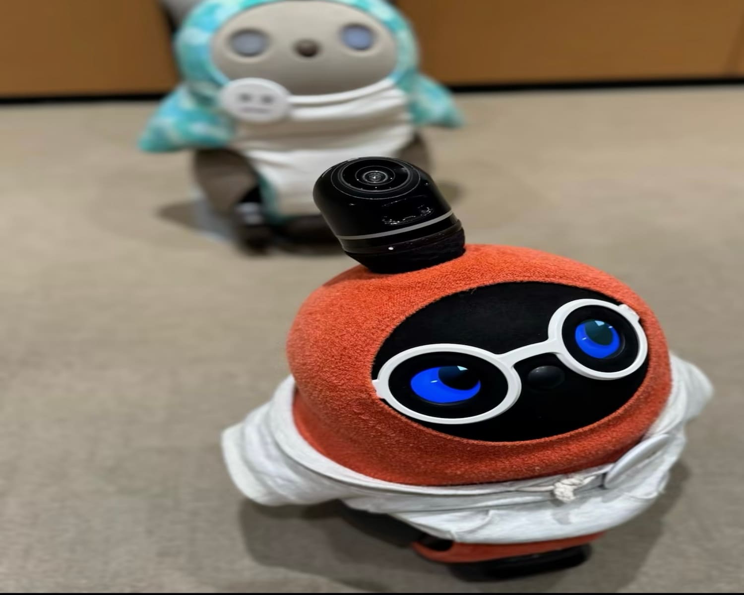 Two compact AI toy robots displayed indoors